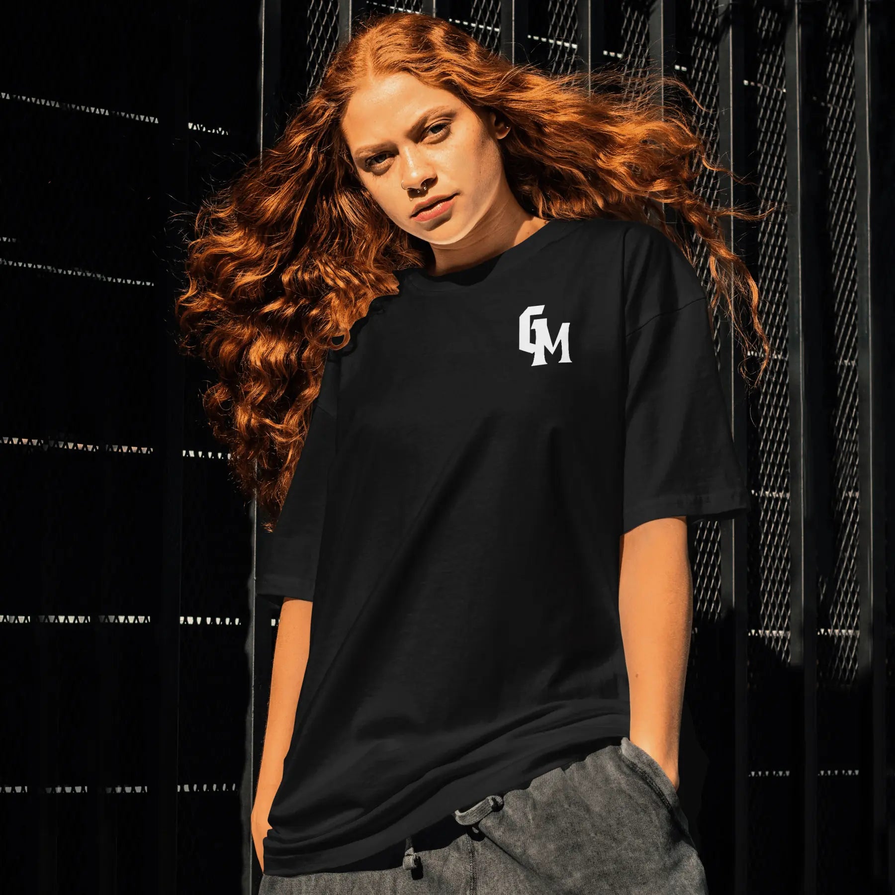 Person wearing a black t-shirt with a gym mentality logo against a dark background